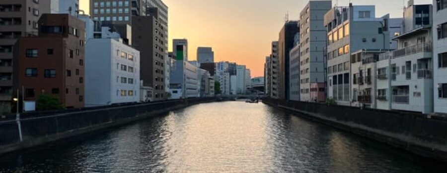 River in Tokyo with buildings on both banks, an image of depth and perspective that mirrors the relationship between posture and how we experience the world.
