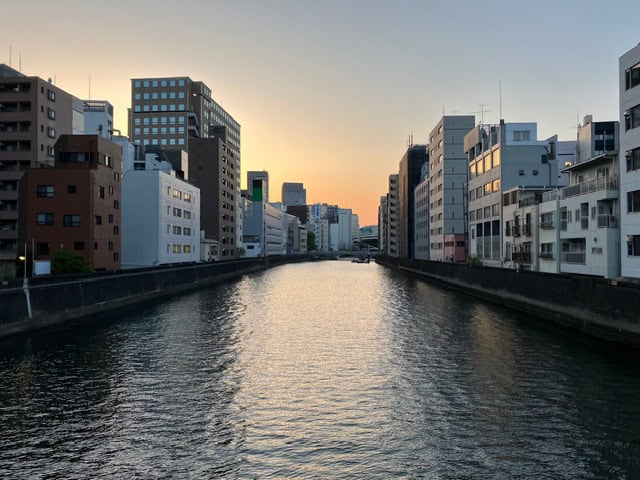 River in Tokyo with buildings on both banks, an image of depth and perspective that mirrors the relationship between posture and how we experience the world.
